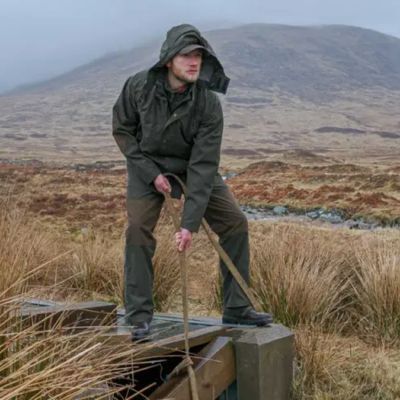 farmer wearing waterproof clothing for wet farm work in hilly terrain