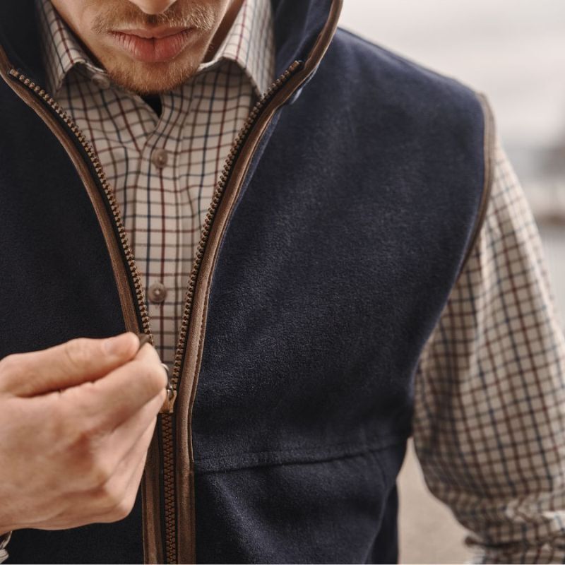 Man wearing a gilet over a check shirt outdoors