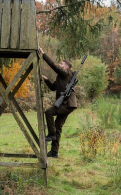 Deer stalker wearing muted clothing in natural cover