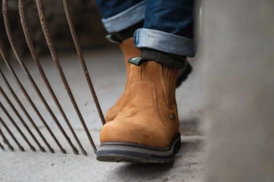 Farmer wearing hoggs of fife air shire dealer boots working on the farm