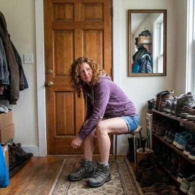 Woman checking how walking boots fit indoors before wearing them outside