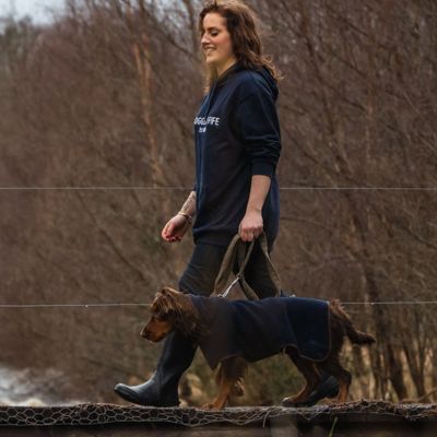 Woman wearing Hoggs Annan hoodie while walking a dog